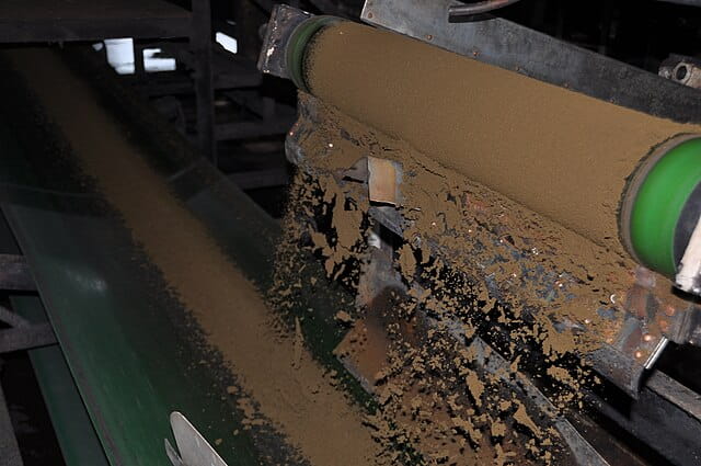 processed CTC tea falling off a roller onto a conveyor